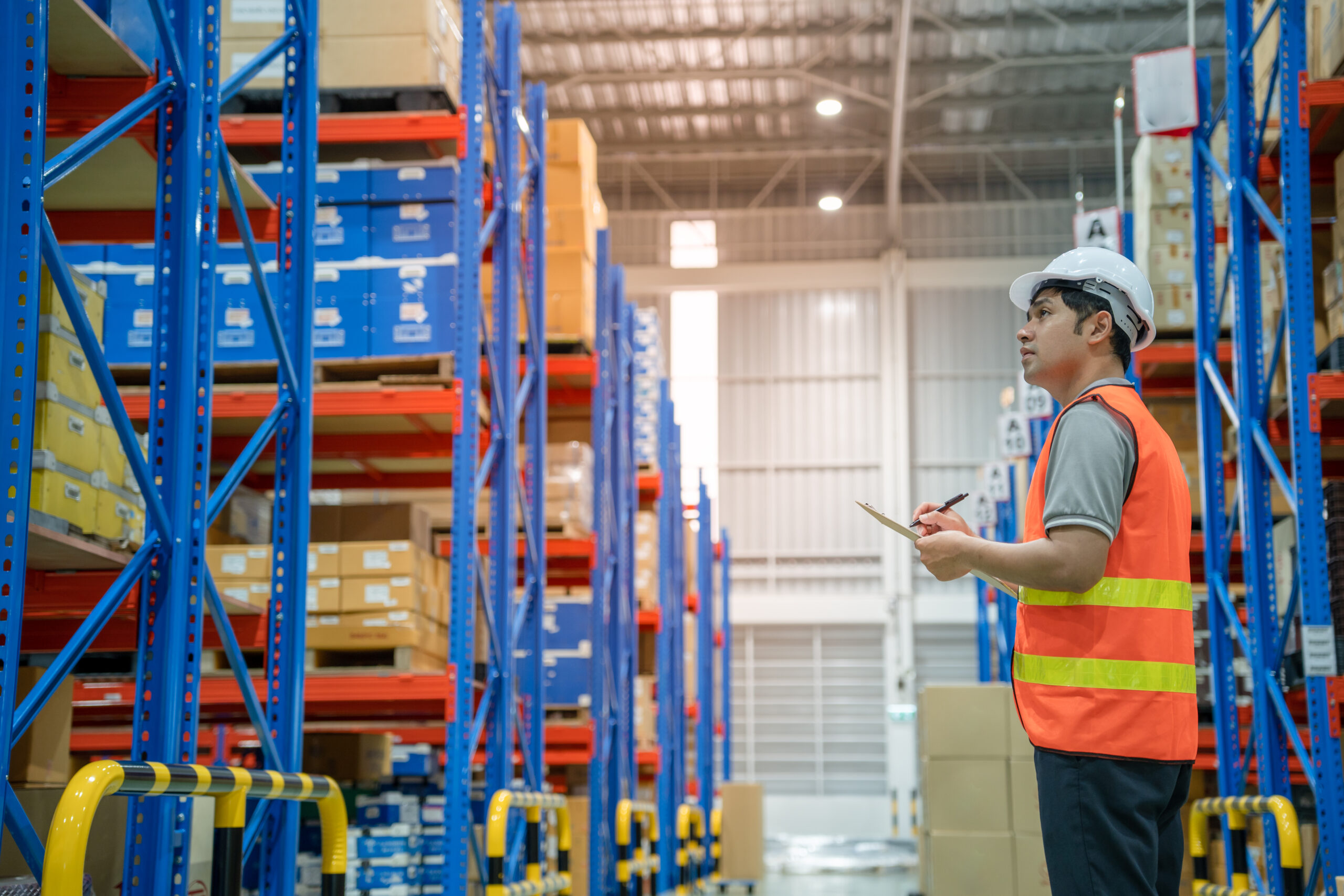 Asian male factory manager inspects goods in warehouse or inventory and check stock product. Transport logistic business shipping and delivery to customers through a freight forwarding company.